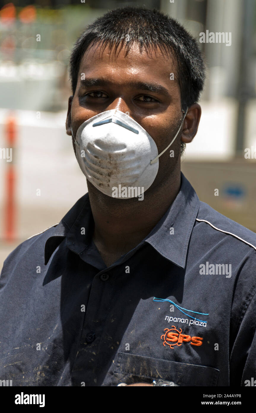 La faccia con una maschera lavoratore coperto aiutando a pulire fino a uno di Brisbane è peggiore alluvione effettuata strade nel Queensland, Australia Foto Stock