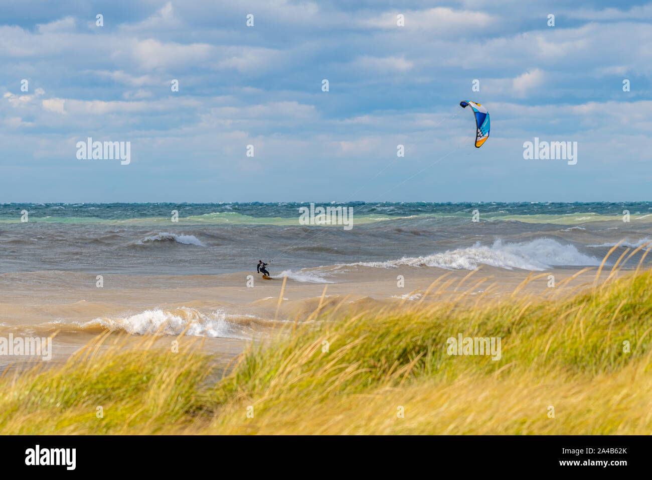 Un uomo kite surf in grandi onde del lago Michigan. Foto Stock