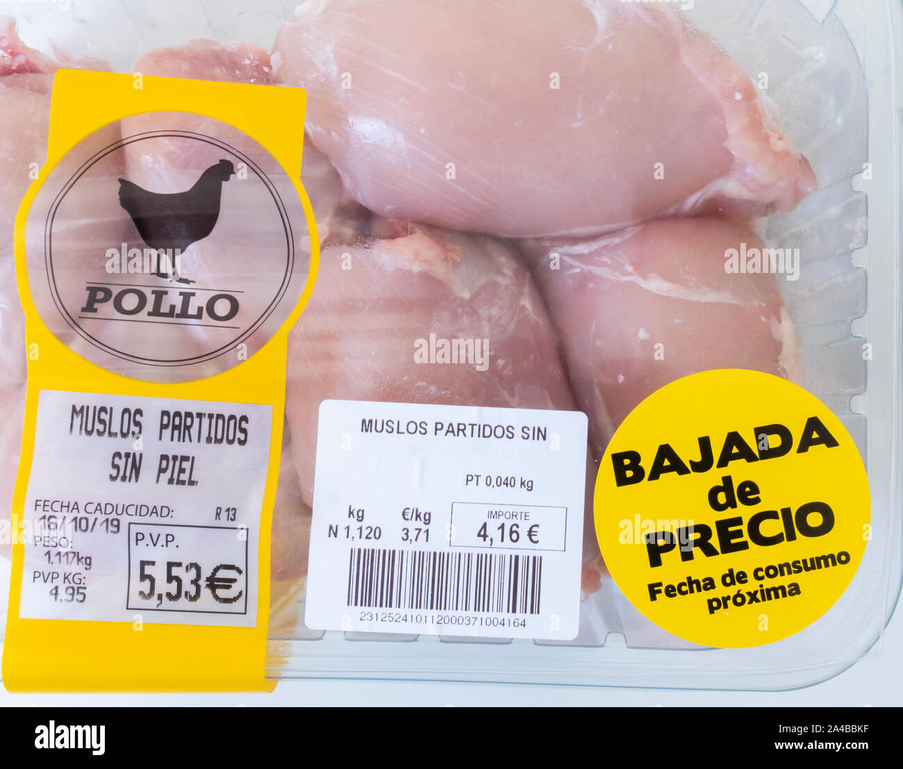 Fresche, pollo senza pelle thighes confezionato in imballaggi di plastica con prezzo ridotto adesivo in un supermercato in Spagna. Foto Stock