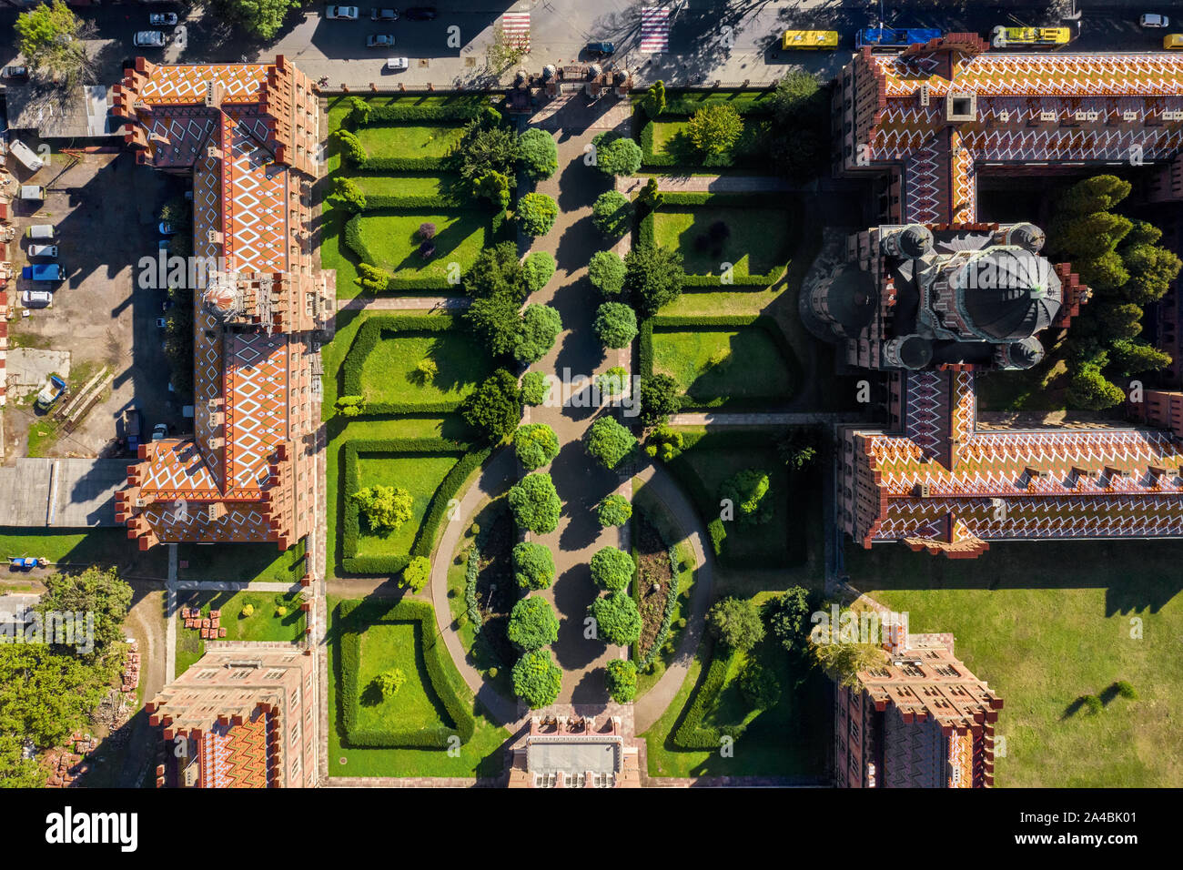 Belle vecchie costruzioni del Chernivtsi Università con torri e cupole intorno al giardino verde con camminamenti in Ucraina. Sole splende su di essi. Top v Foto Stock