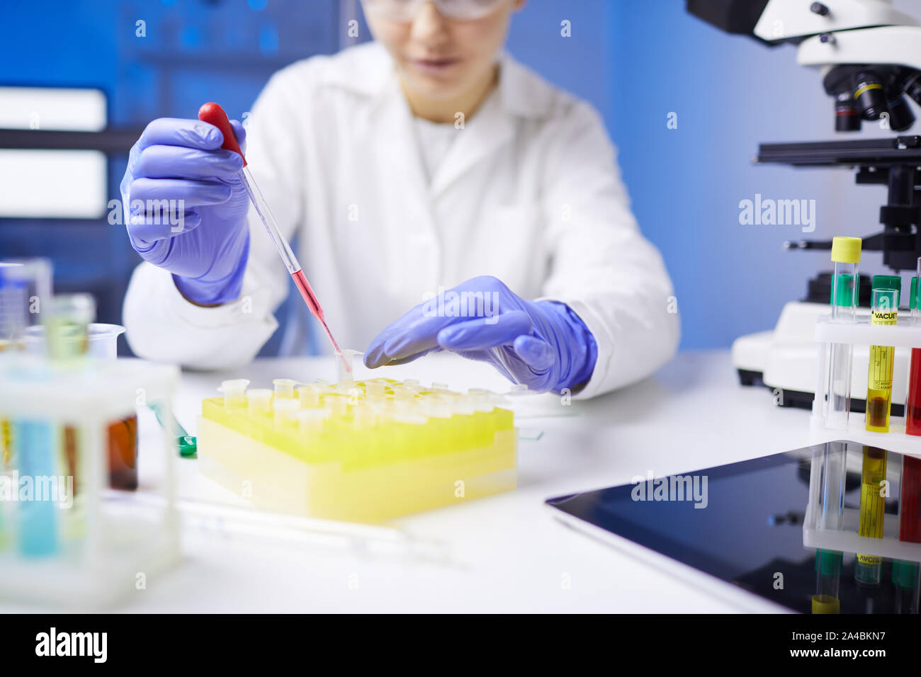 Close up di un irriconoscibile donna scienziato preparazione campione di sangue usando un contagocce mentre si lavora sulla ricerca medica in laboratorio, spazio di copia Foto Stock