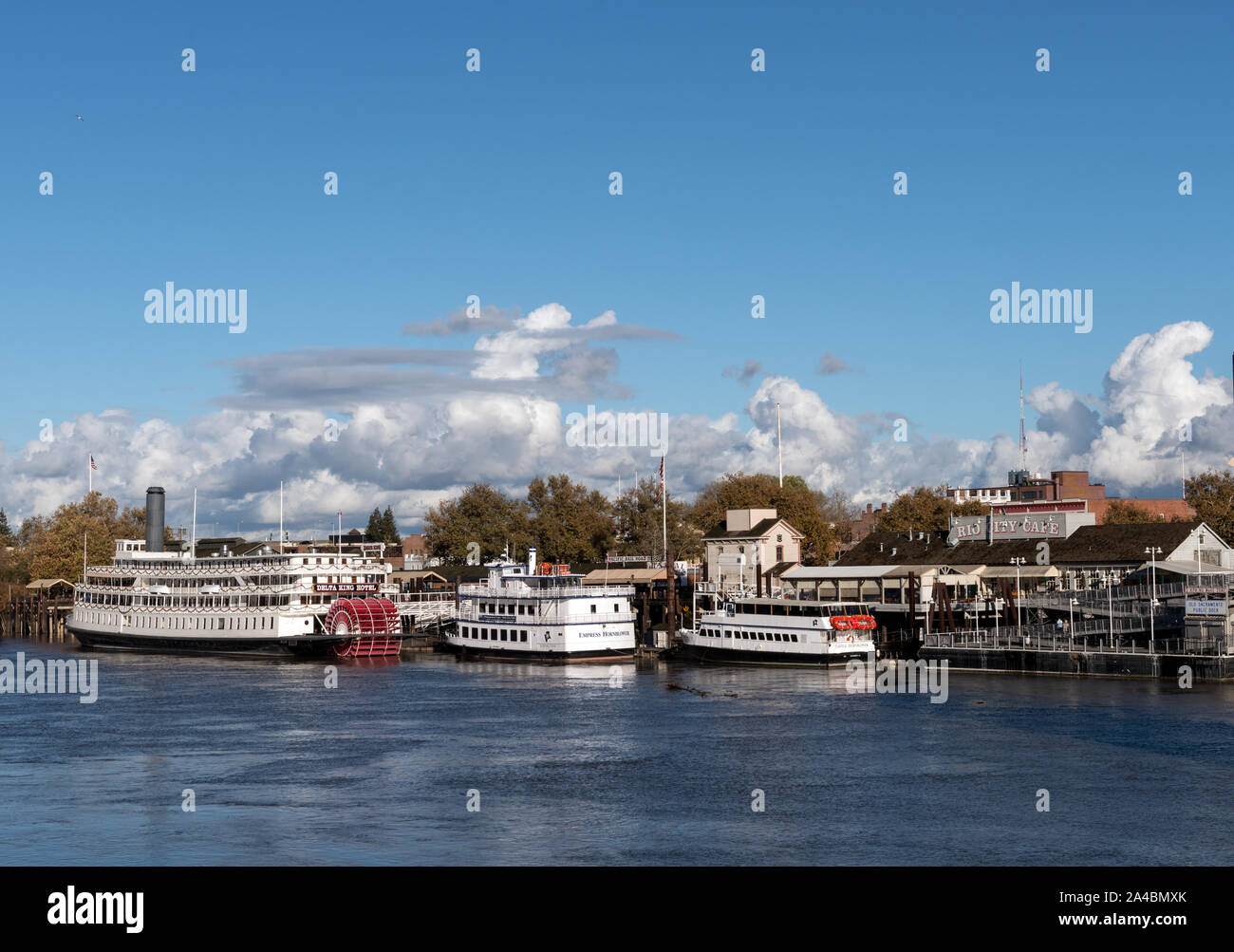 Il Delta King pedalo' sternwheel steamboat e altri riverboats, ancorata al di sotto della vecchia sezione di Sacramento del centro di Sacramento, California la città capitale della Foto Stock