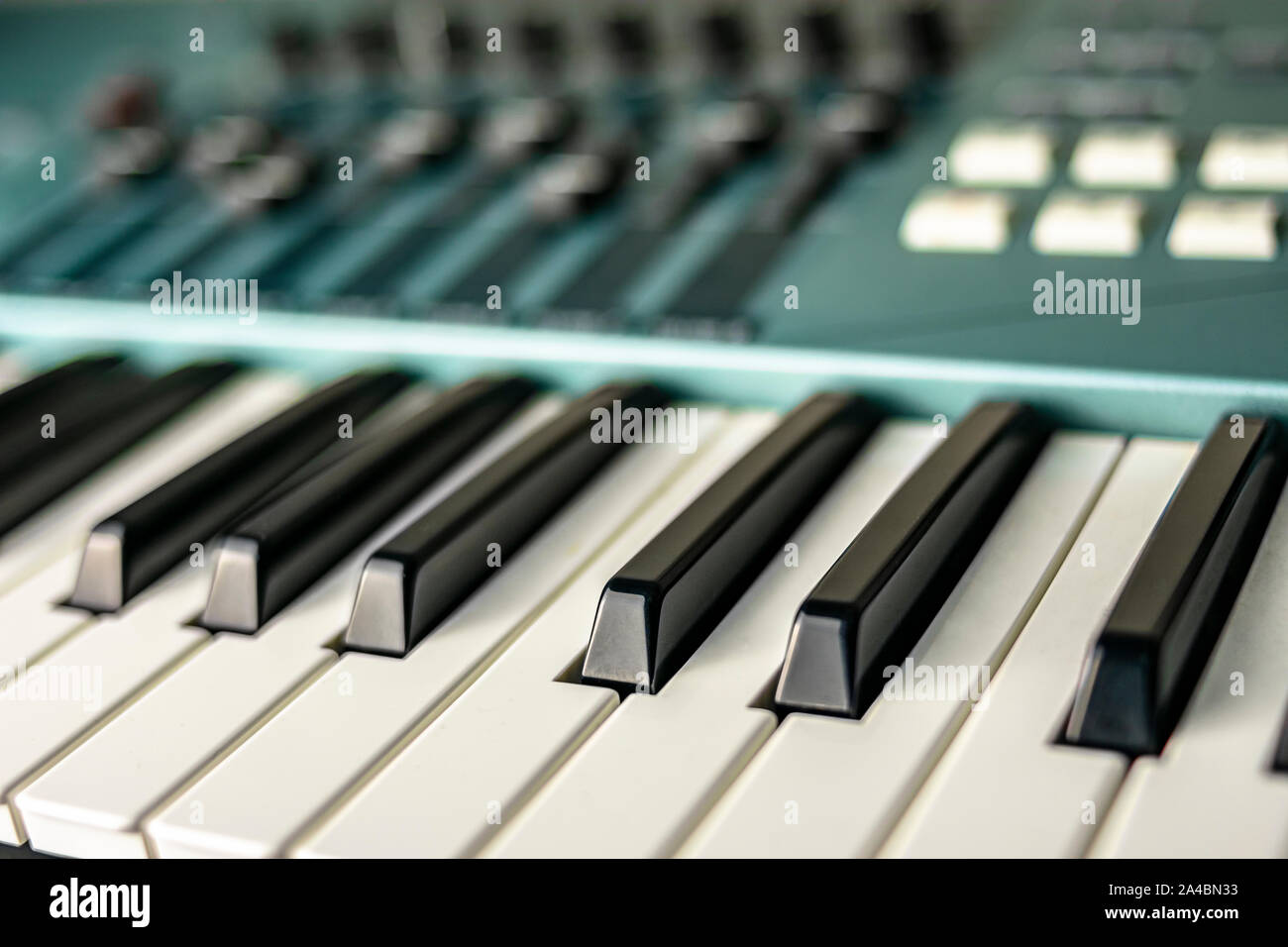 Close-up di naturale e sostenuta tasti di una tastiera di fase o pianoforte, insieme con le tastiere di comando e i fader Foto Stock