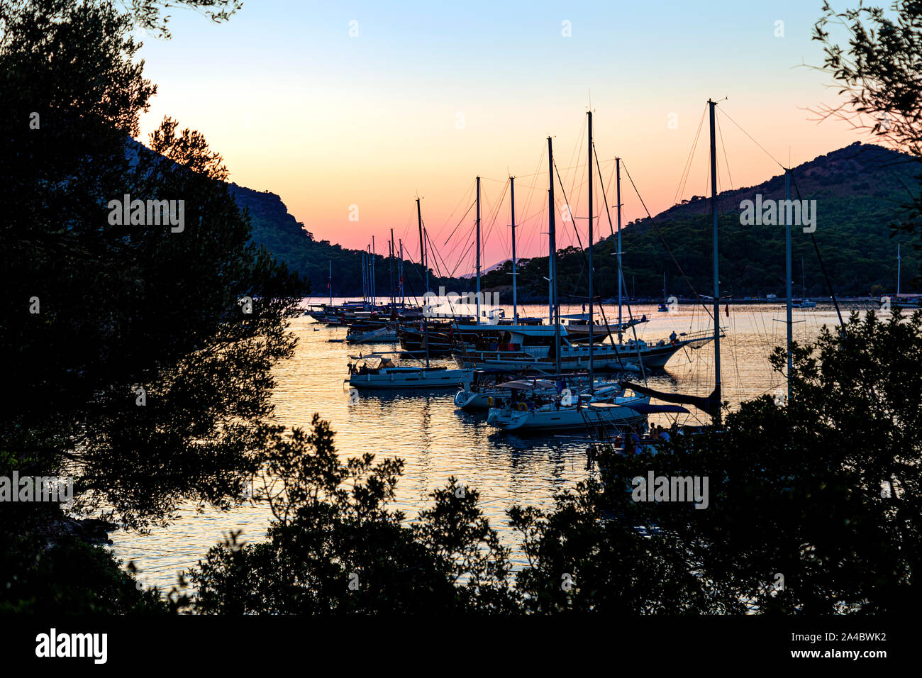 Barche a vela ancorato da Gemiler Island al tramonto, Riviera Turca, Turchia Foto Stock