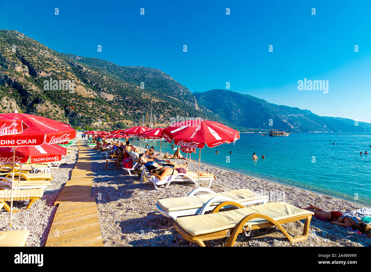 Spiaggia con ombrelloni e lettini prendisole a Oludeniz, Riviera Turca, Turchia Foto Stock