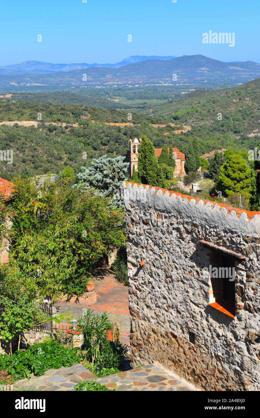 Muro di pietra sulla cima di una collina in una tipica inglese storica città vecchia nel sud della Francia. Le maestose montagne, foreste e steeple in background. Francia Foto Stock