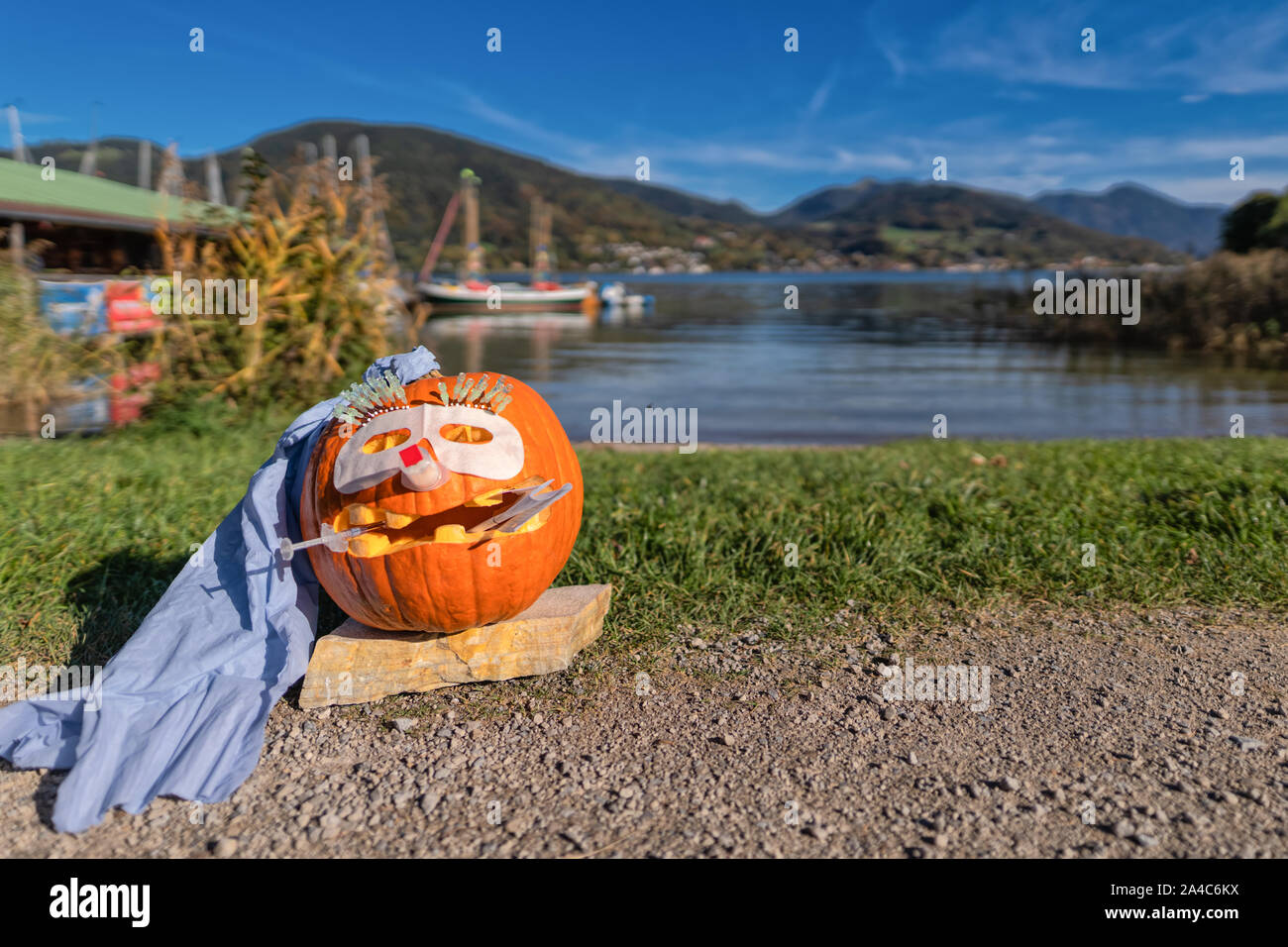 Un medico helloween zucca al di fuori di fronte a un idilliaco lago. Foto Stock