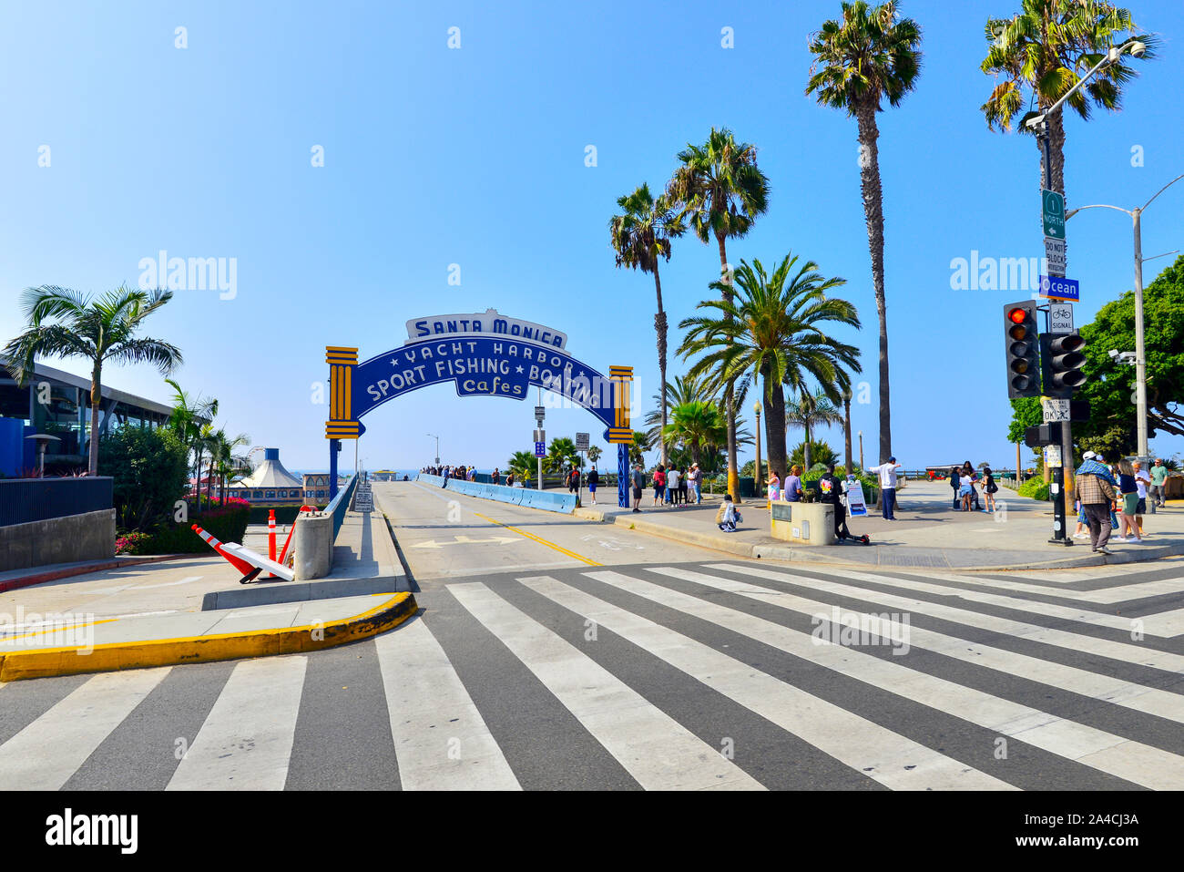Ingresso a Santa Monica Pier mostra segno arcuata sul molo di entrata e palm strada alberata Foto Stock