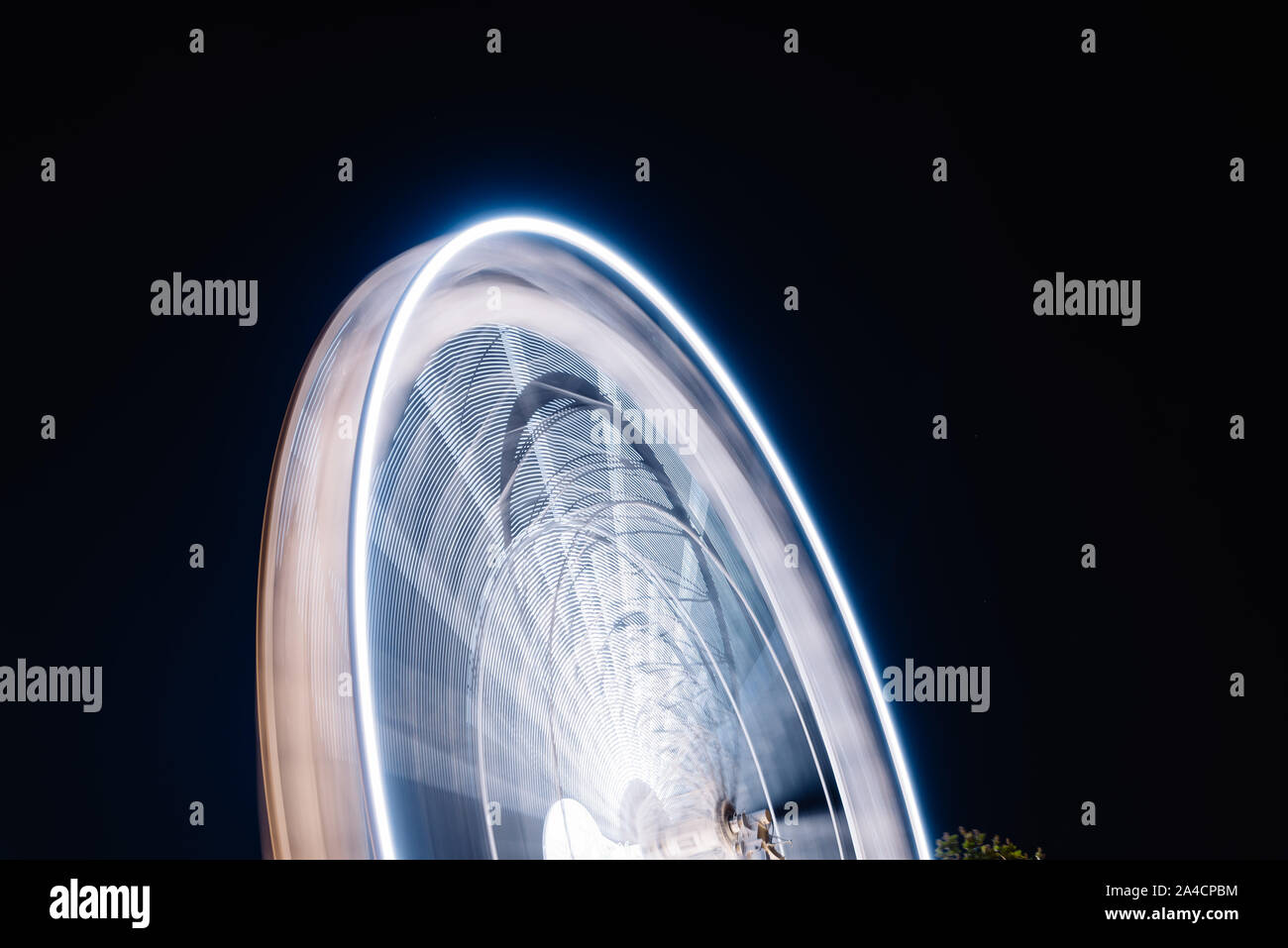 Ruota panoramica Ferris la filatura lunga esposizione neon struttura contro la notte nera a La Rochelle Foto Stock