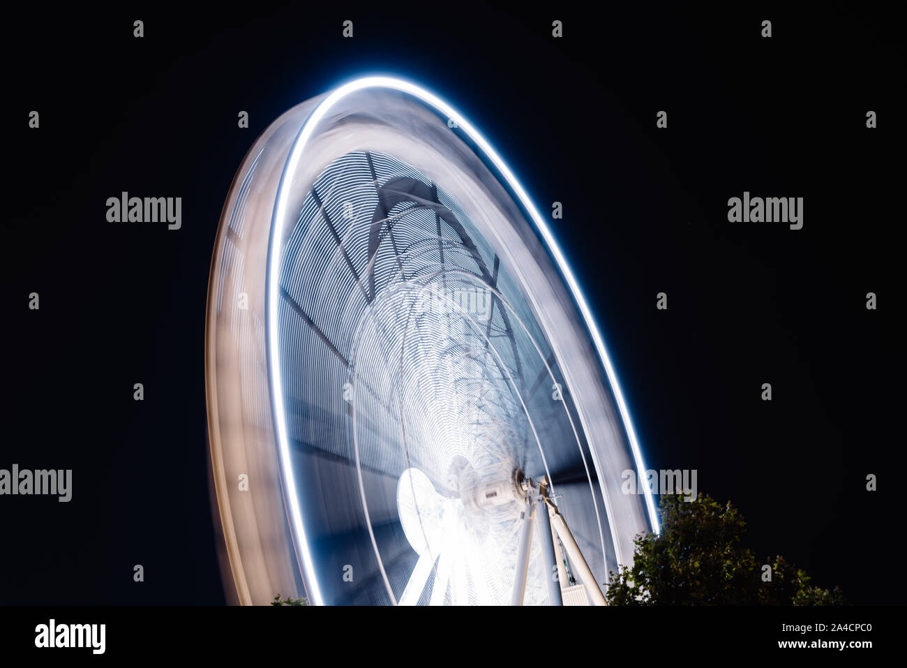 Ruota panoramica Ferris la filatura lunga esposizione neon struttura contro la notte nera a La Rochelle Foto Stock