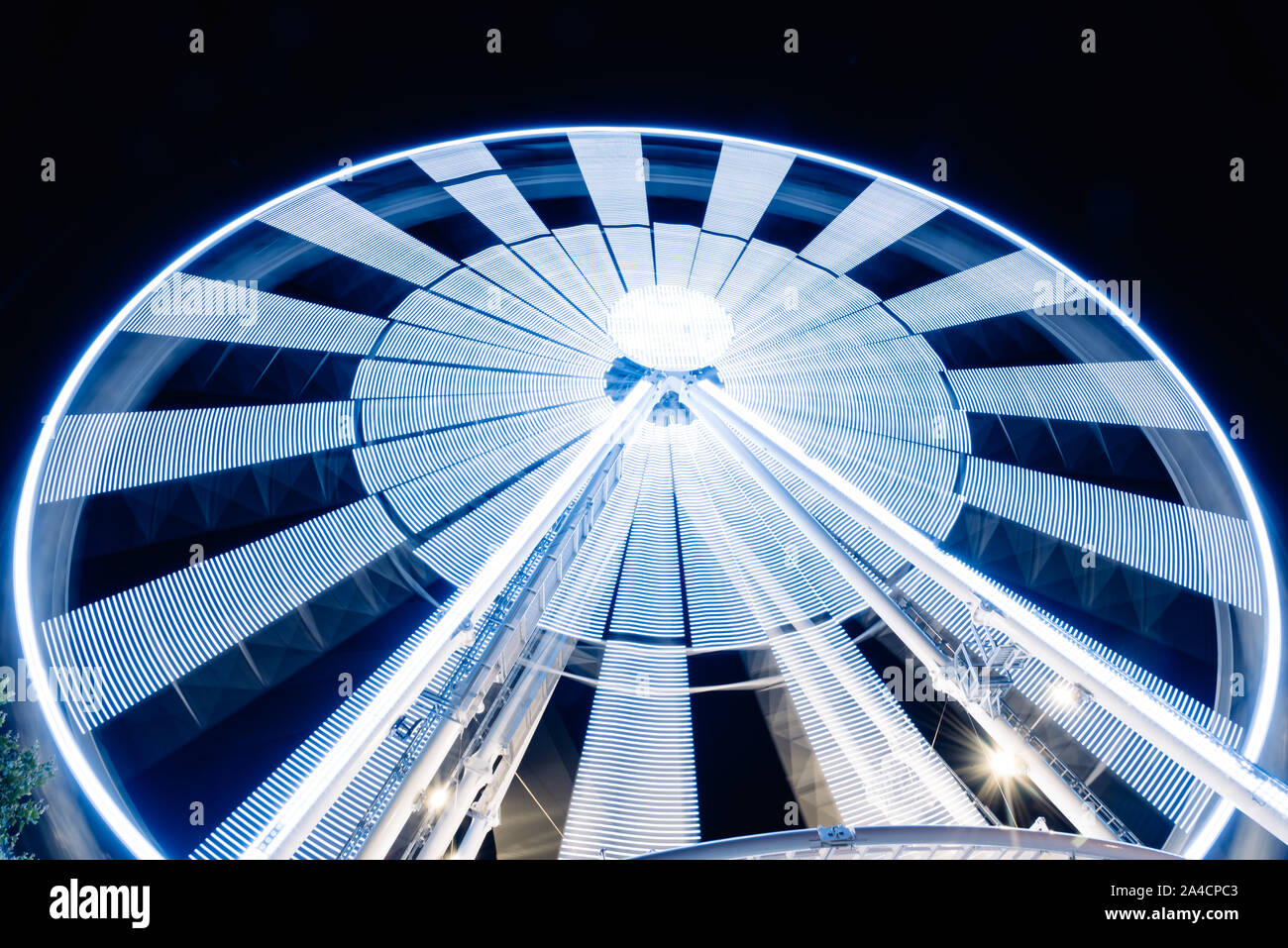 Ruota panoramica Ferris la filatura lunga esposizione neon struttura contro la notte nera a La Rochelle Foto Stock