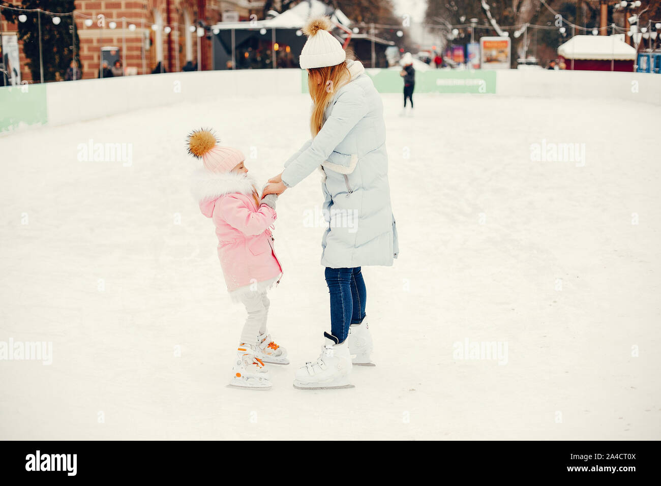 La famiglia in un parco d'inverno. Madre e figlia in un ice arena Foto Stock