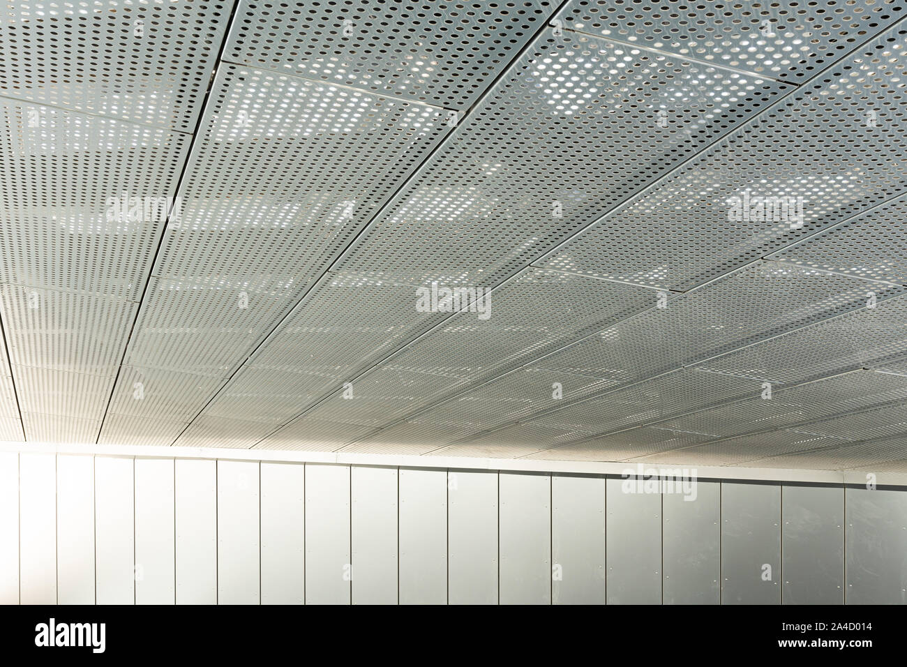 Vista diagonale di metall griglie e fori tondi in metallo superficie di soffitto, pannelli perforati Foto Stock