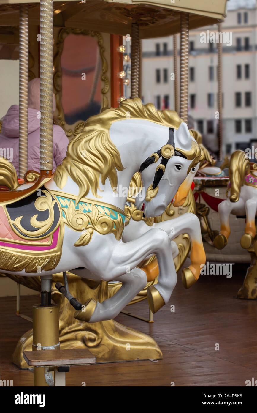 Giostra cavalli di close-up. La testa di un cavallo giocattolo con un golden mane. Città parco di divertimenti, scenario di Natale Foto Stock