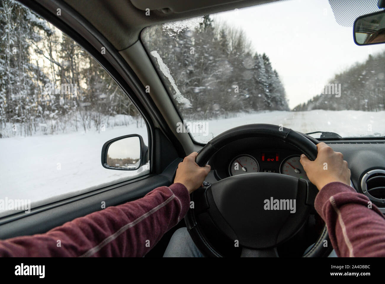 Un uomo aziona un auto su una strada di inverno Foto Stock