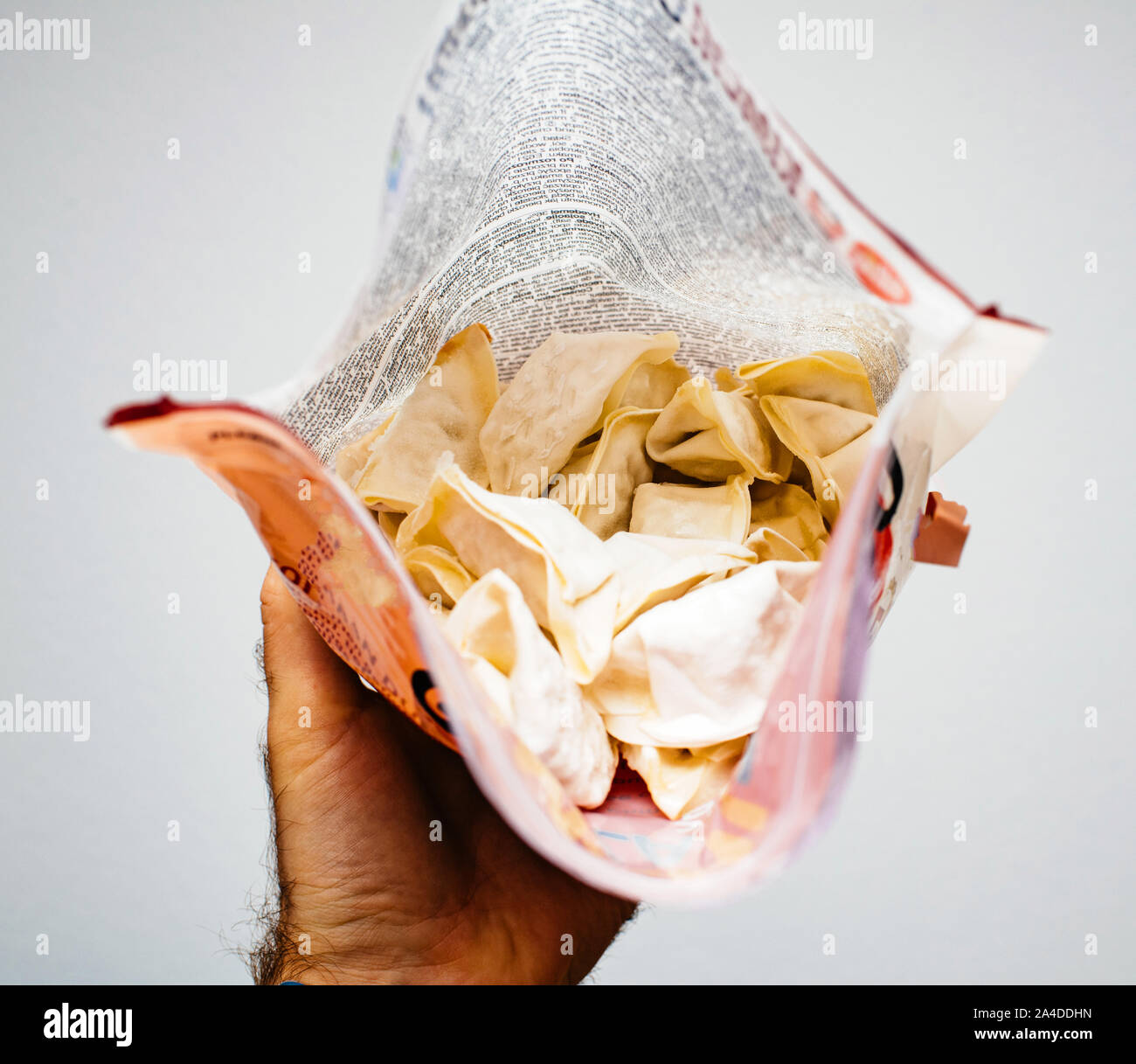 Man mano che tiene il pacchetto di prodotti congelati Jiaozi un cinese gnocco, comunemente consumati in Cina e in altre parti dell Asia orientale Foto Stock