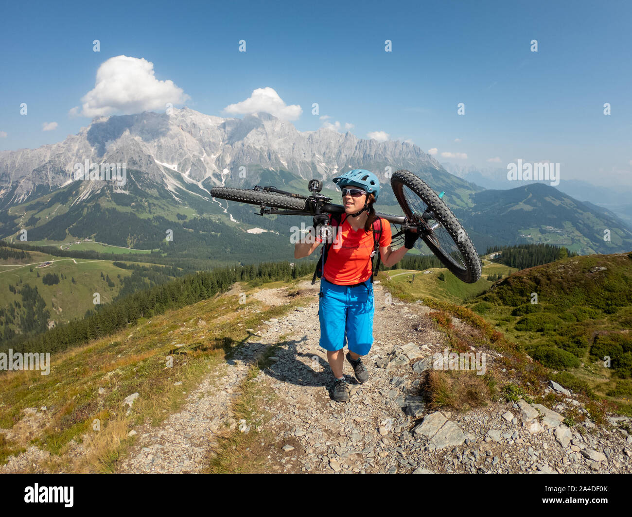 La donna che porta la sua mountain bike su un sentiero alpino, Hochkoenig, Dienten, Salisburgo, Austria Foto Stock