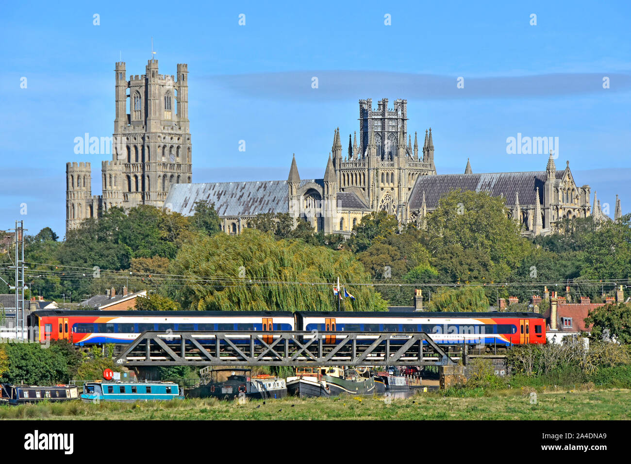 Cambridgeshire barche sul Fiume Great Ouse sotto il ponte ferroviario treno parte della stazione di Ely East Anglia Fens paesaggio vedute della Cattedrale di Ely Regno Unito Inghilterra Foto Stock