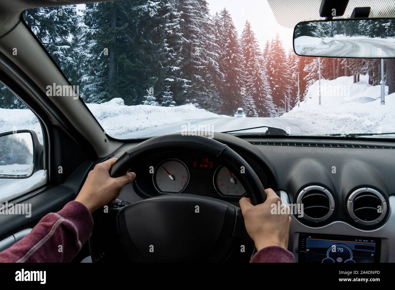 Un uomo aziona un auto su una strada di inverno Foto Stock