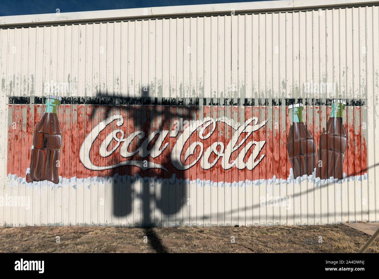 L'ombra di un palo telefonico gli accenti di un vecchio Coca-Cola segno su un edificio esterno Alpine, Texas Foto Stock