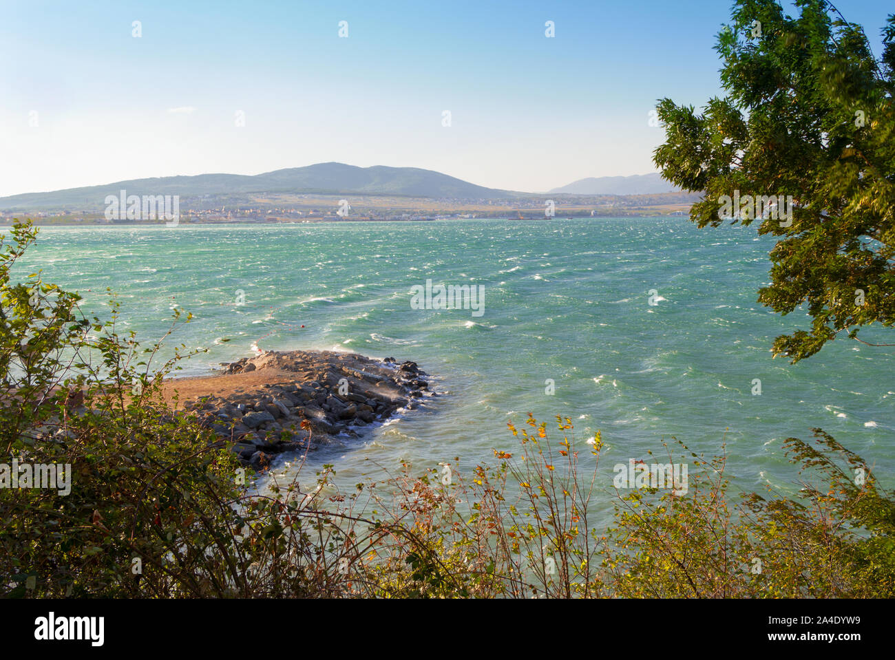 Tempo ventoso in mare sullo sfondo. Tempesta nella baia di Gelendzhik causati dal vento sulle montagne. Il mare turchese onde con schiuma di cresta. Succursali di piegatura Foto Stock