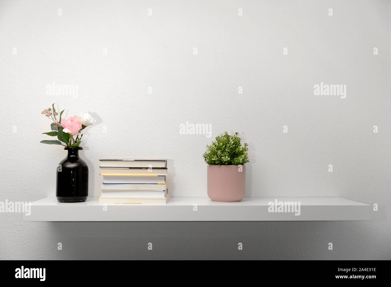 Bookshef sul muro bianco con decorazioni Foto Stock