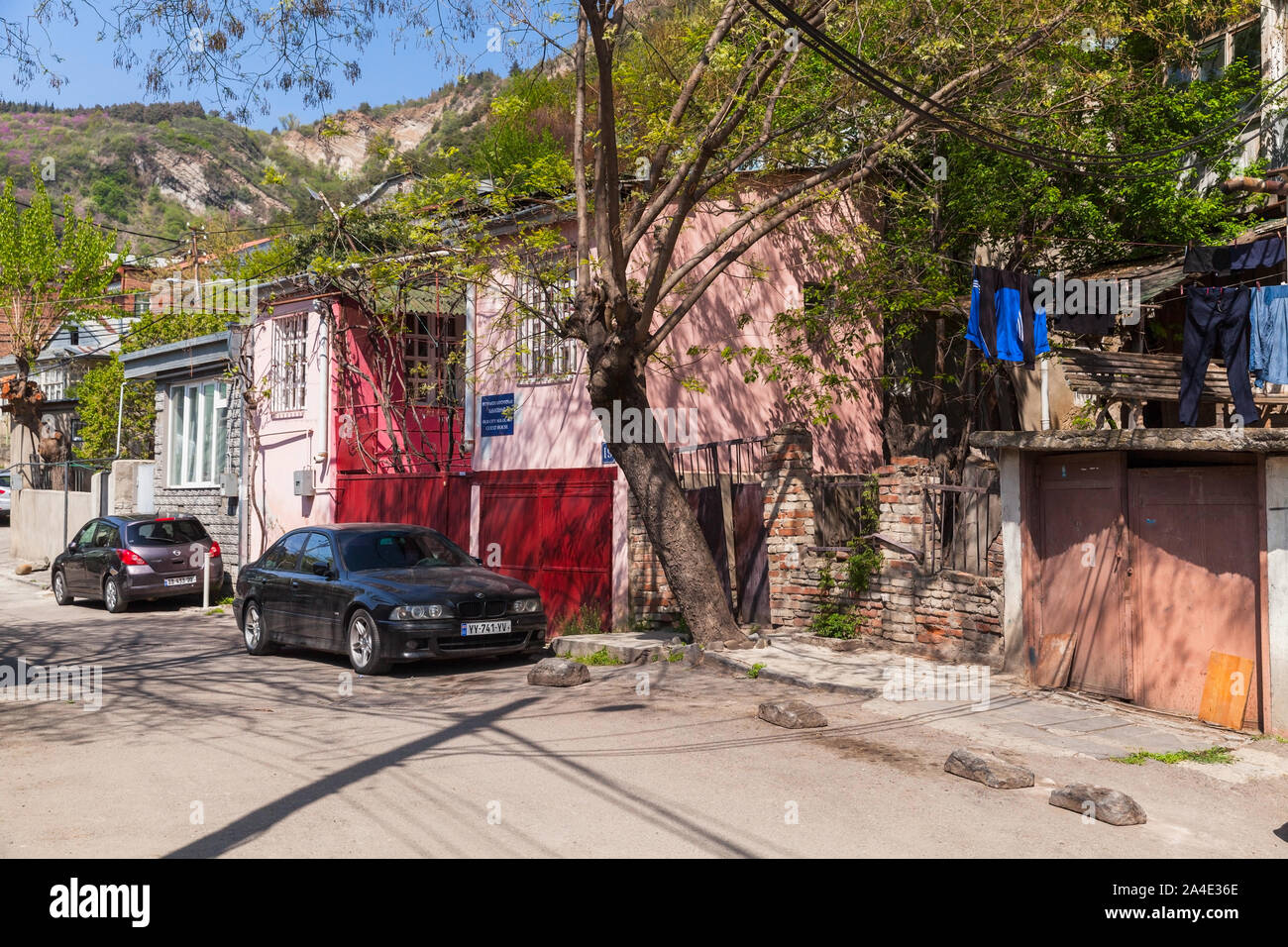 Tbilisi, Georgia - 28 Aprile 2019: Tbilisi street view con le auto parcheggiate vicino a vecchie case di vita Foto Stock