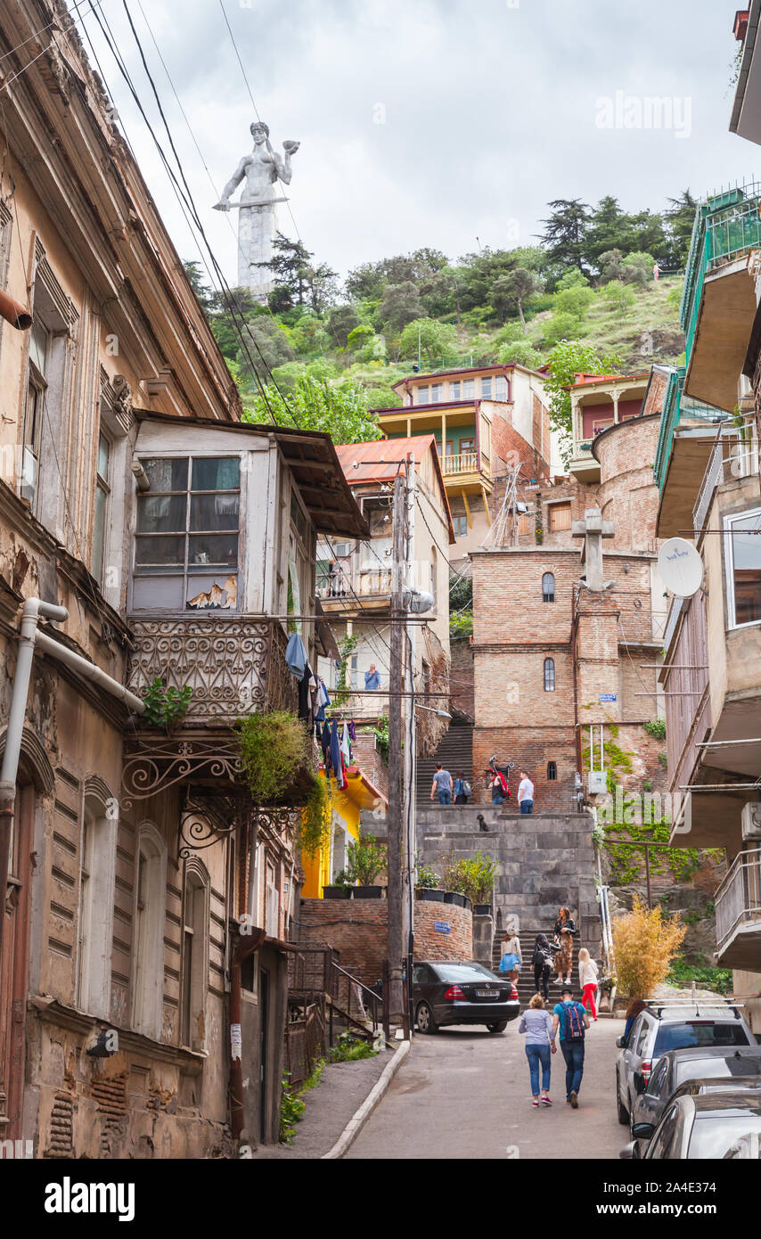 Tbilisi, Georgia - 03 Maggio 2019: Vecchia Tbilisi street view con Kartlis Deda monumento sullo sfondo. La gente comune a piedi la strada Foto Stock