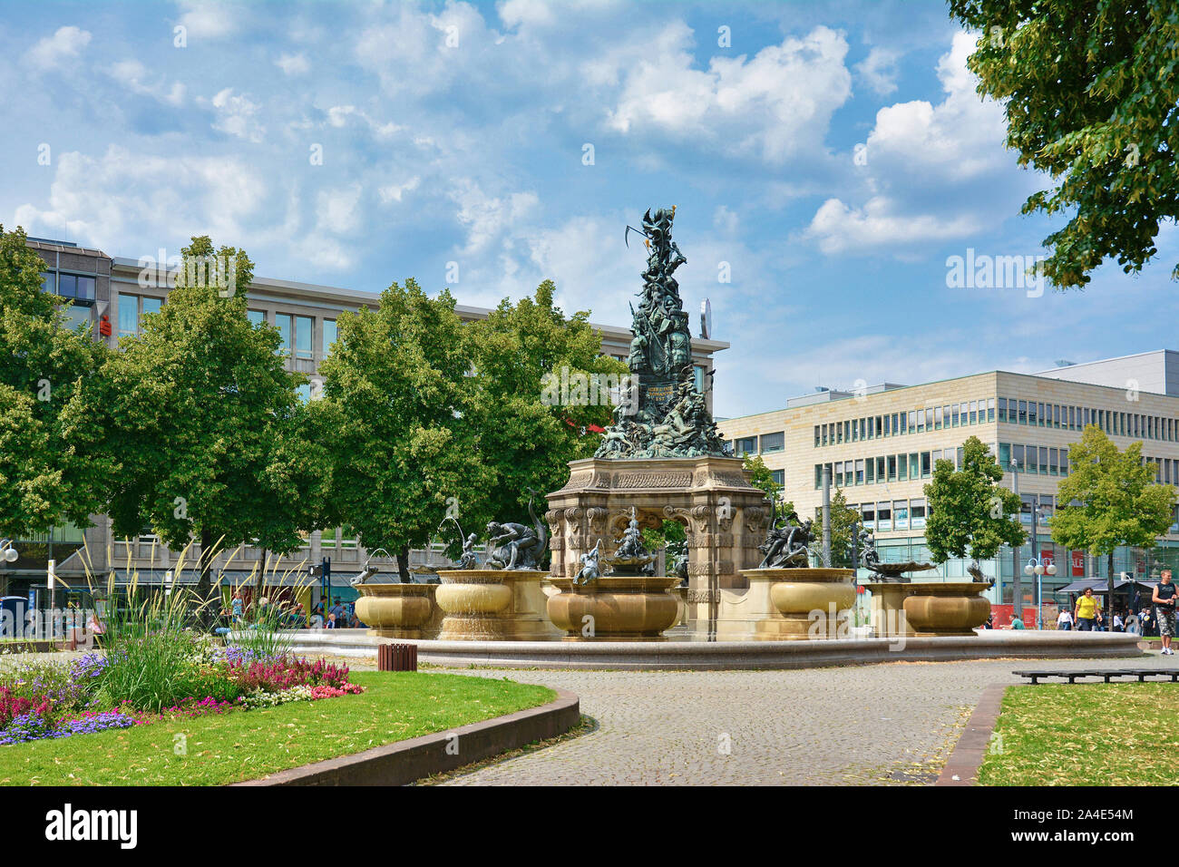 Mannheim, Germania - Agosto 2019: Fontana denominata "Grupello Piramide' con sculture nel parco di piccole dimensioni a piazza chiamata "Paradeplatz' nel centro della città Foto Stock