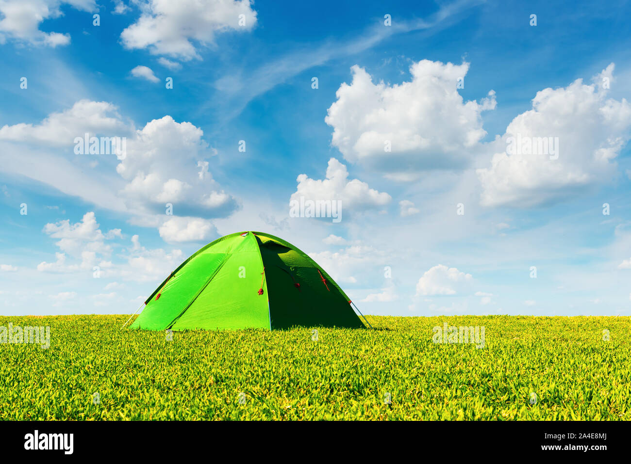 Tenda verde sul prato estivo blu su sfondo con cielo nuvoloso. Magnifico verde altopiano. Fotografia di paesaggi Foto Stock