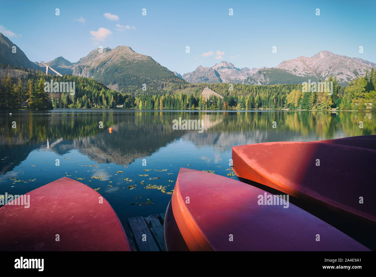 Barche rosse sul villaggio di Strbske Pleso lago. Posizione: Alti Tatra National Park, Slovacchia. Filtro Instagram Foto Stock