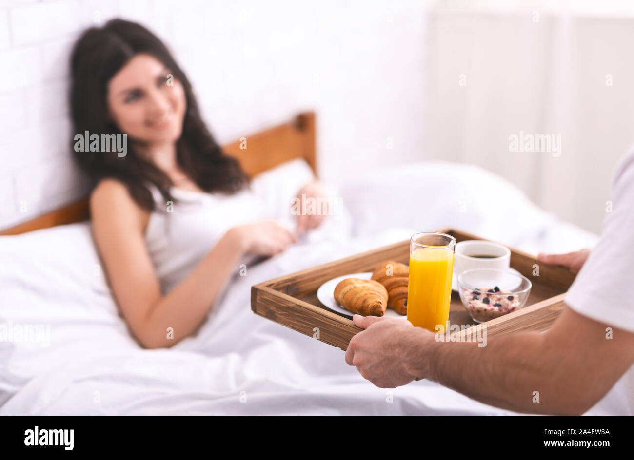 Bel ragazzo portare la colazione alla sua ragazza in mattinata Foto Stock