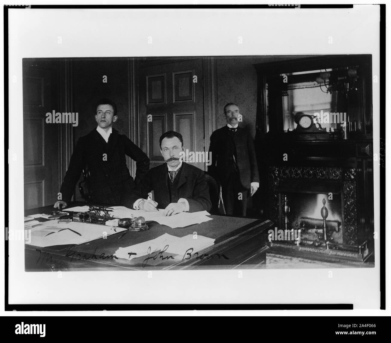 Tre Dipartimento del Tesoro dipendenti, il sig. Graham, John Brown, e un altro uomo, poste in un ufficio con un caminetto Foto Stock