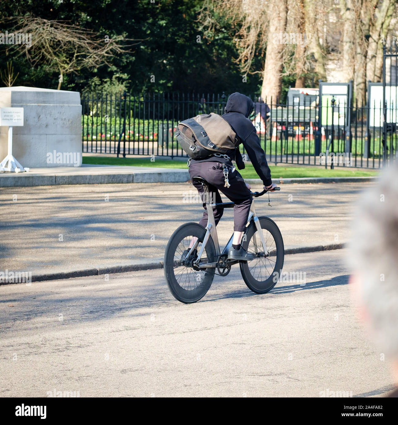 " Commuter " sulla sua bicicletta su una strada in un parco a Londra Foto Stock