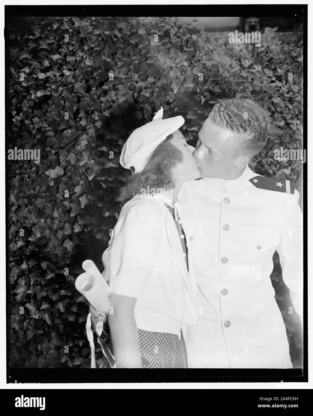 Per la victor appartengono il bottino. Annapolis, Md. Giugno 1. Walter B. Miller, che oggi è stato commissionato come un alfiere in esercizi di laurea presso l'U.S. Accademia navale riceve un bacio di benvenuto di congratulazioni dalla sua fidanzata Betty Varina equipaggi. Entrambi sono da Columbia, S.C. Foto Stock