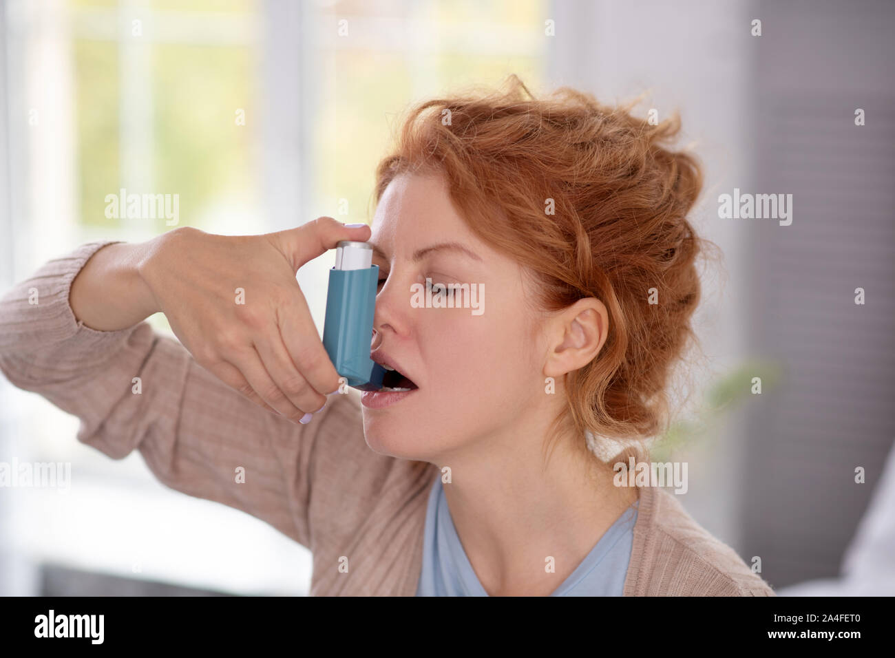 Donna che utilizza inalatore mentre avente attacchi di asma Foto Stock