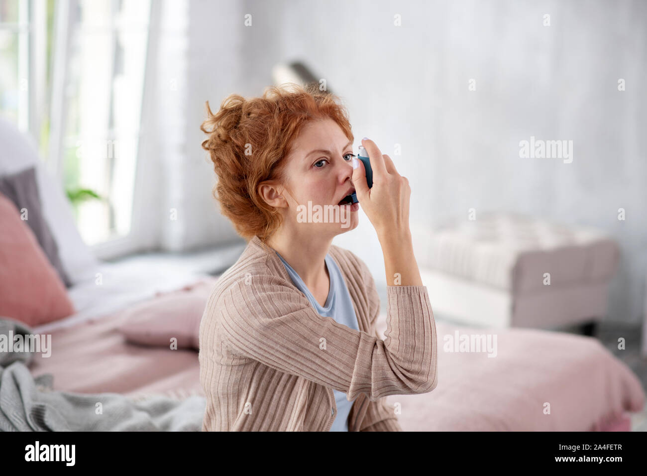 I capelli rossi donna graziosa avente inattesi attacchi di asma Foto Stock