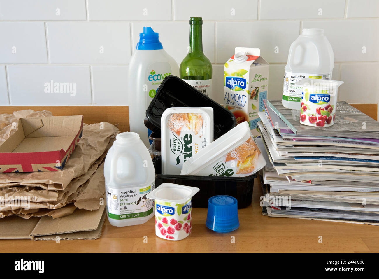 Articoli per la casa sul piano cucina pronti per il riciclaggio inclusa la plastica, carta, cartone e vecchi cataloghi. Foto Stock