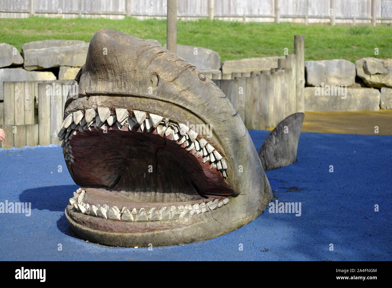 Marwell Zoo, Hampshire, Inghilterra, Regno Unito. Grande squalo di legno sculture in area gioco per bambini a Marwell Zoo Foto Stock