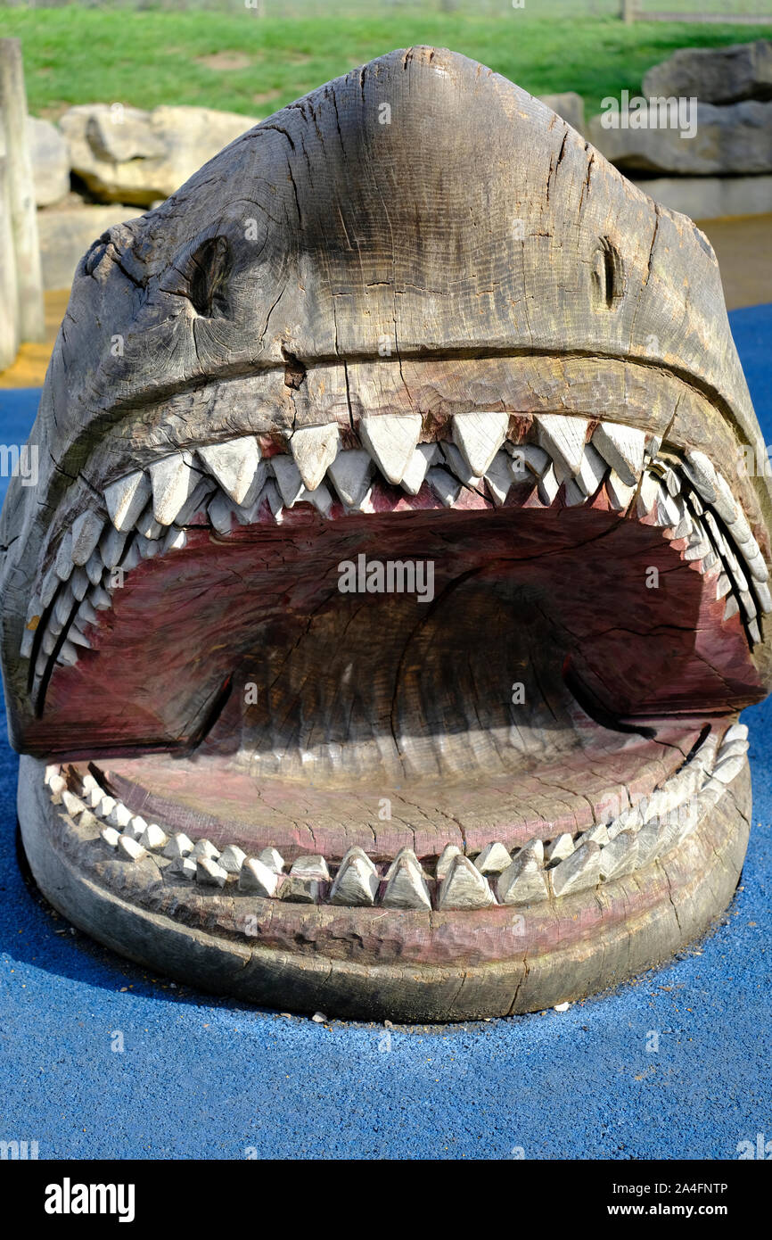 Marwell Zoo, Hampshire, Inghilterra, Regno Unito. Grande squalo di legno sculture in area gioco per bambini a Marwell Zoo Foto Stock