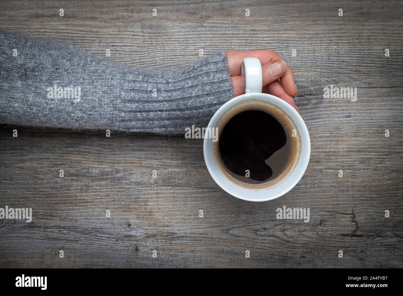 Mano che regge una tazza di caffè nero Foto Stock