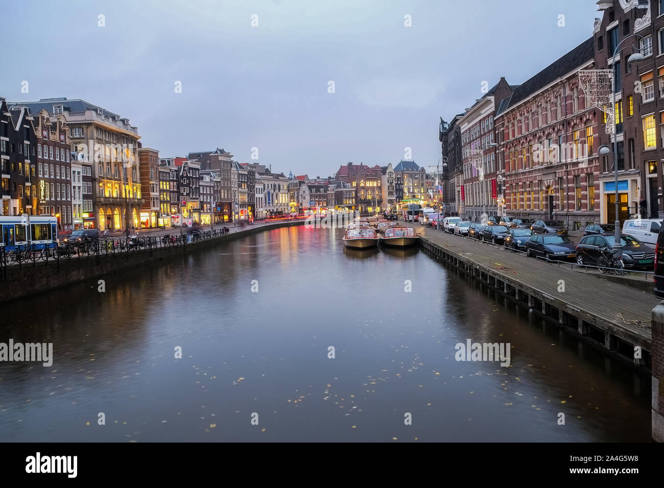 Illuminati canali di Amsterdam vista,imbarcazioni turistiche e architettura tradizionale Foto Stock