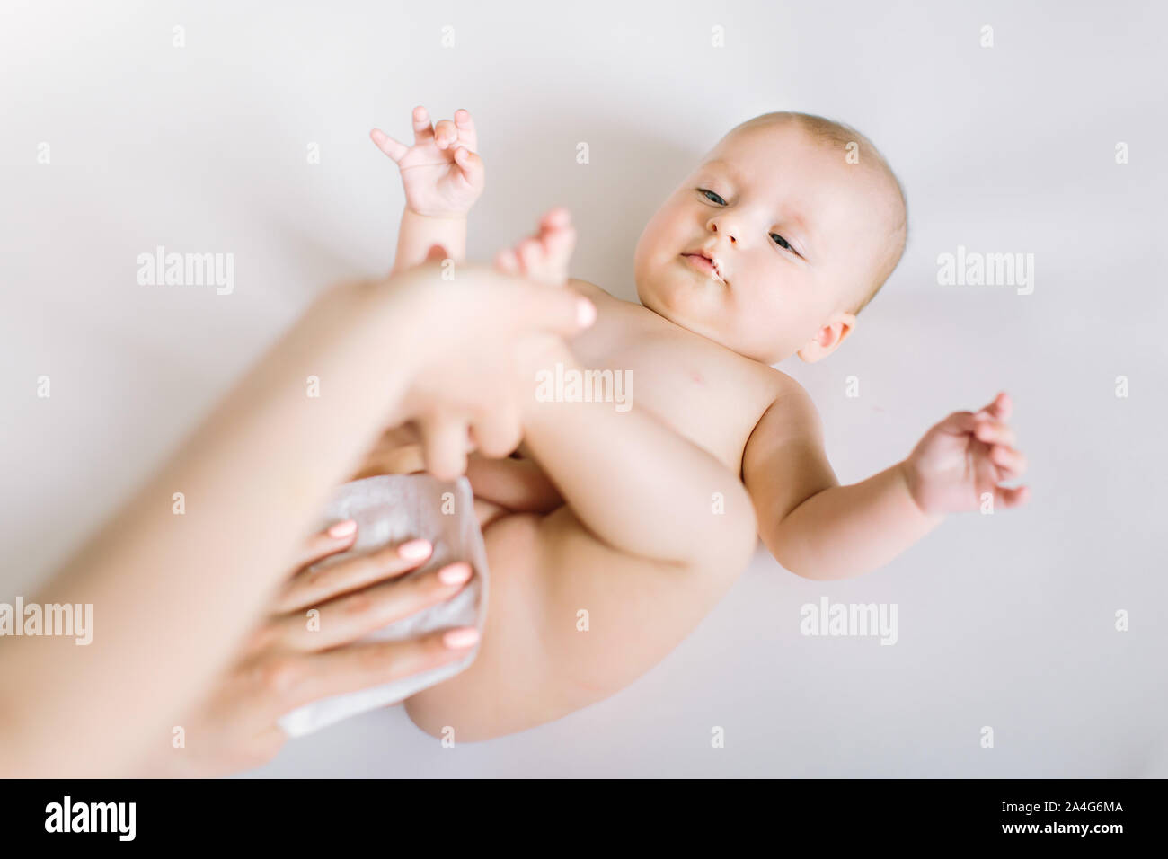 Neonato ottenere un cambio del pannolino: mom tergi bimbo di fondo con baby wipe. Foto Stock