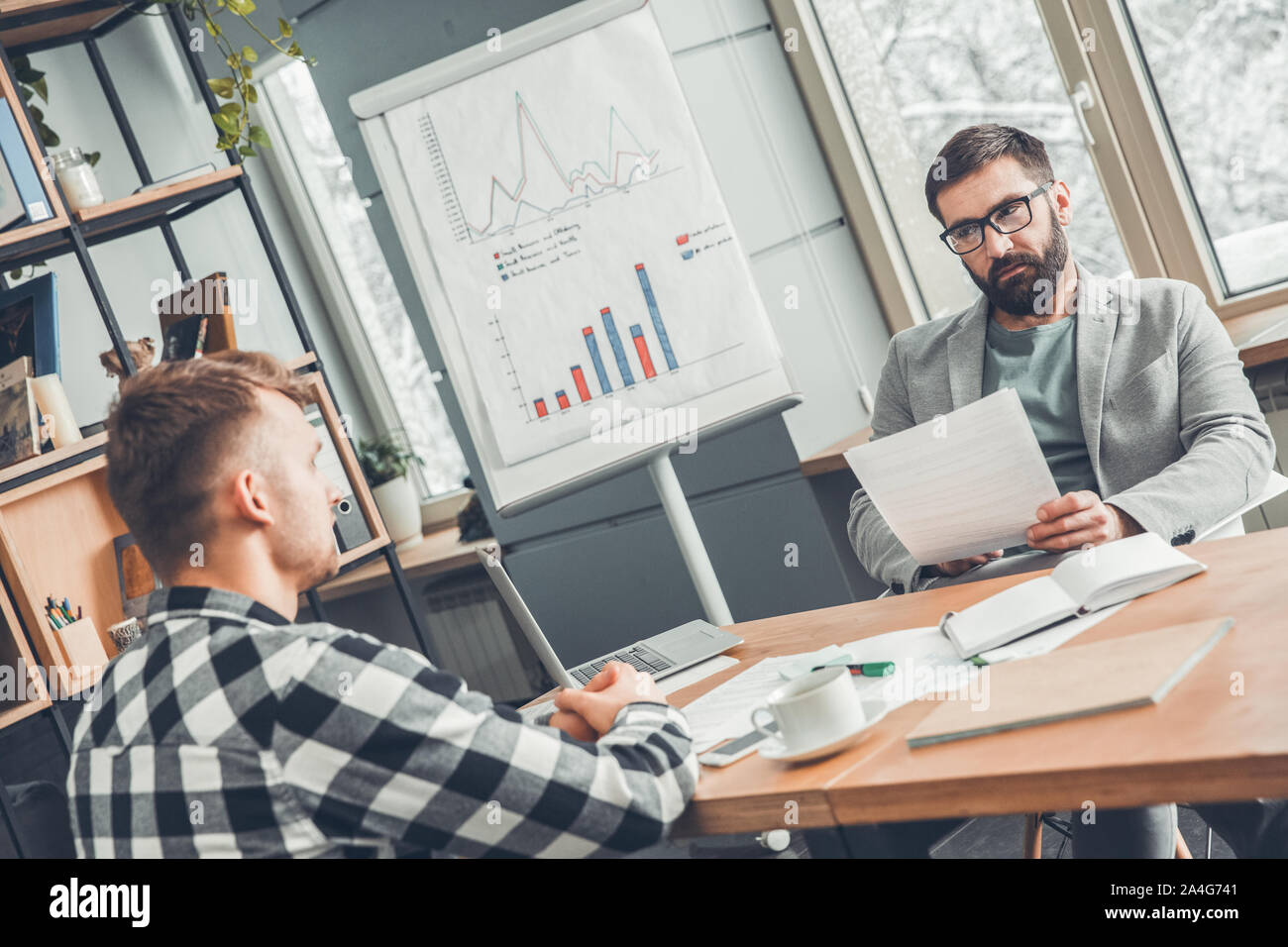 Startupers maschio lavorando insieme a Office seduta guardando ogni altro grave Foto Stock