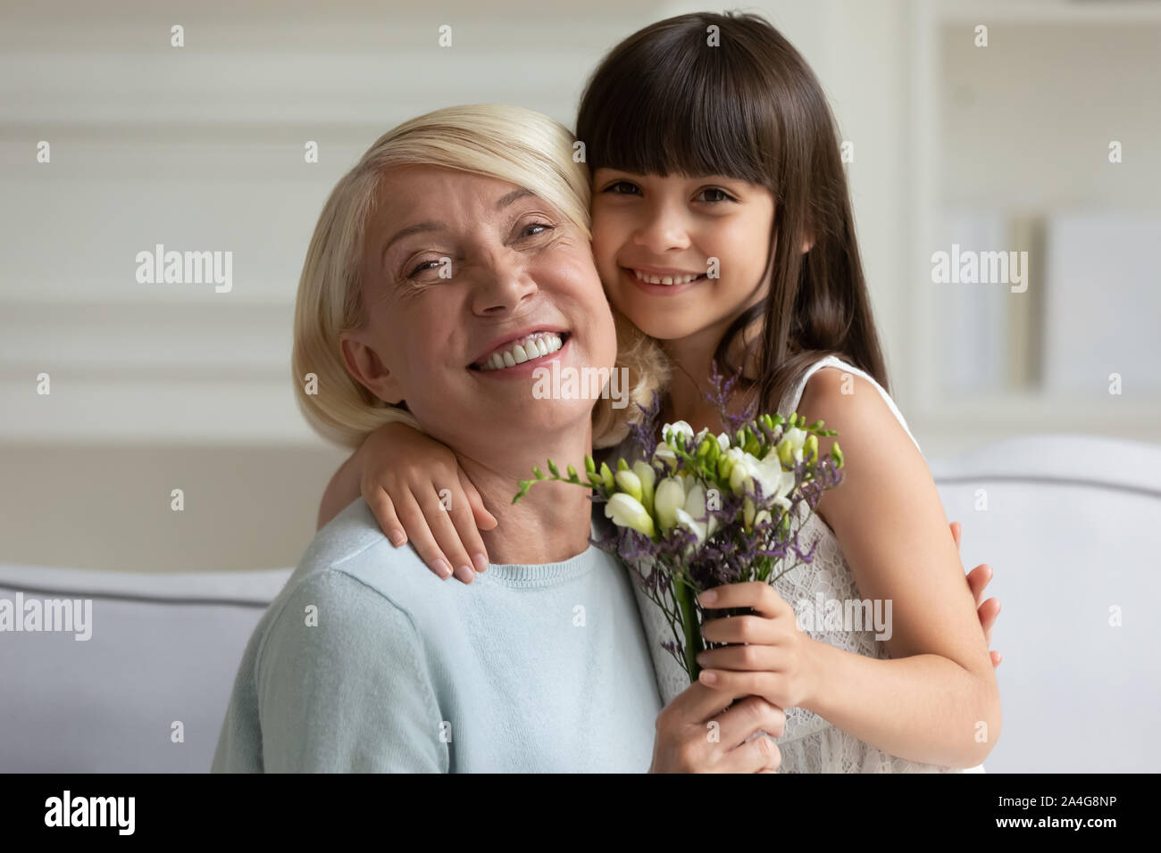 Colpo alla testa ritratto nonna felice abbracciando poco carino nipote. Foto Stock