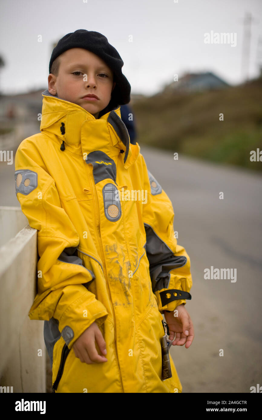 Ragazzo indossando giacca pioggia Foto Stock