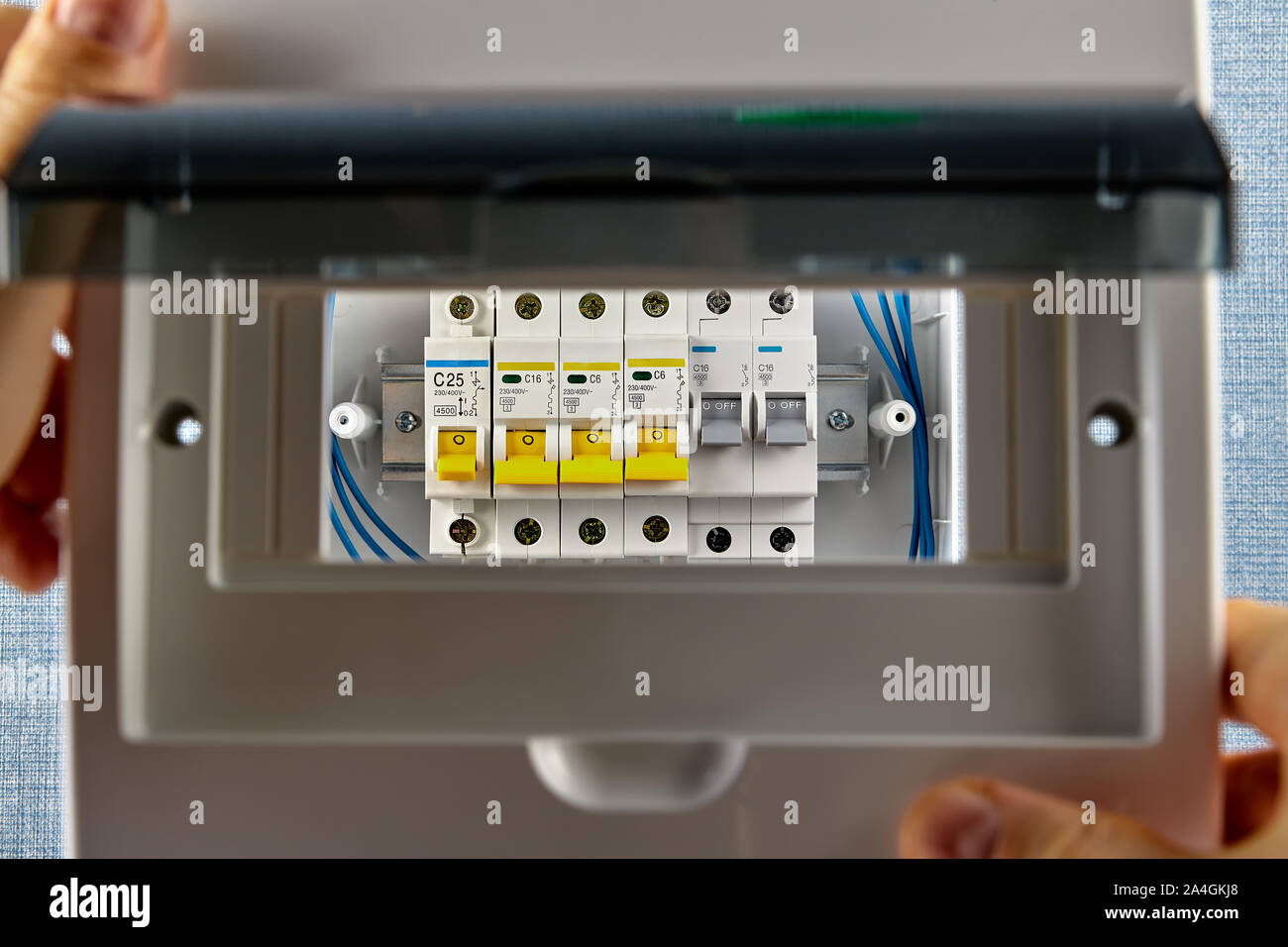 Installazione di impianti elettrici di quadri fusibili o unità consumatore. Gli interruttori automatici sono alloggiati in una scatola di interruttore. Un tuttofare installa i fusibili nel cablaggio domestico Foto Stock