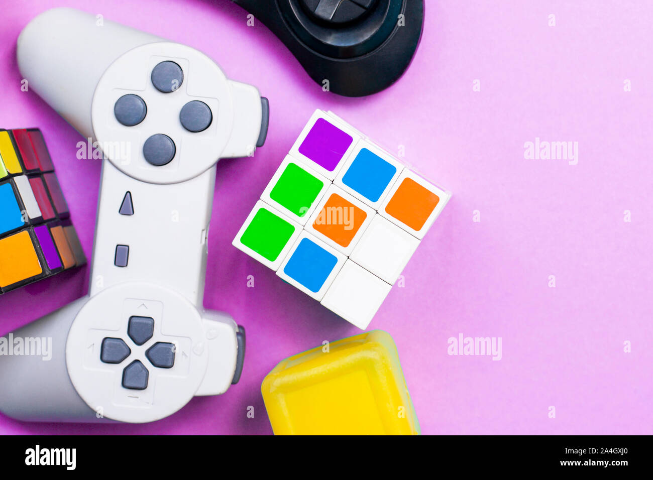 Sfondo di gioco. Console video e giochi da tavola elementi su rosa luminoso dello sfondo. Vari pezzi di gioco. Spazio di copia Foto Stock