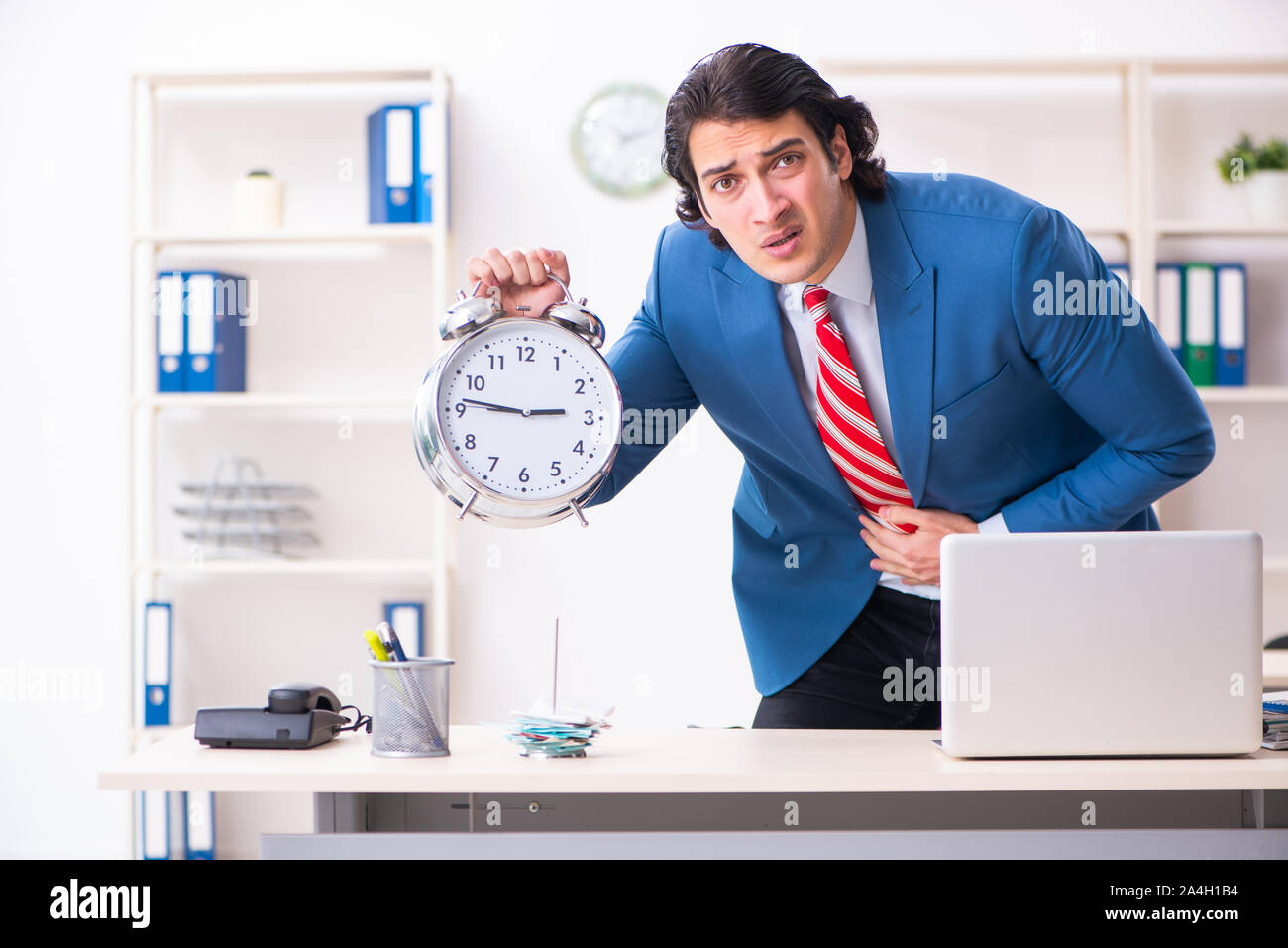 Il giovane maschio sofferenza dei dipendenti in ufficio Foto Stock