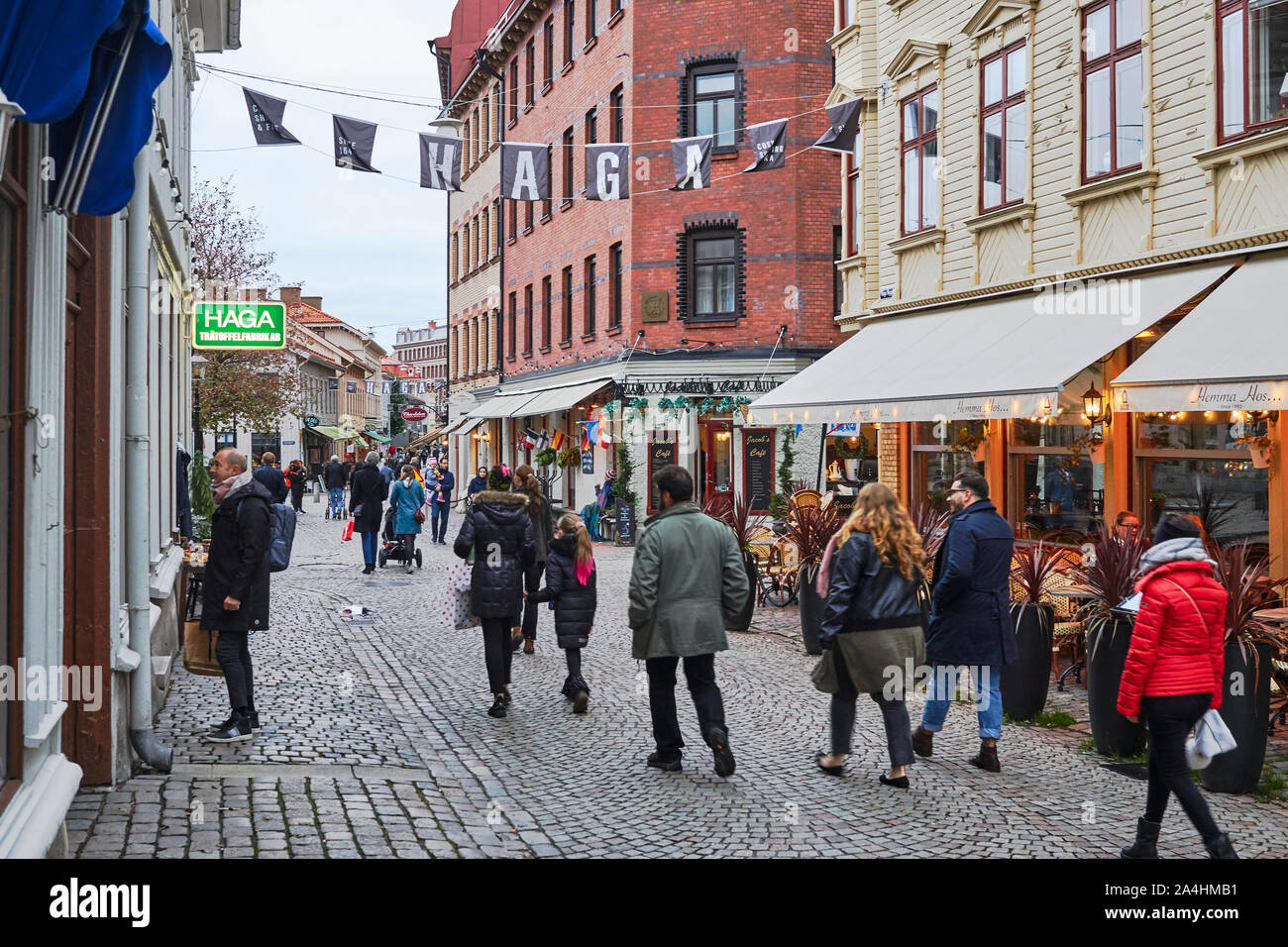 La gente di window shopping nel pomeriggio a Göteborg pittoresco quartiere di Haga drappeggiati in autunno al crepuscolo Foto Stock